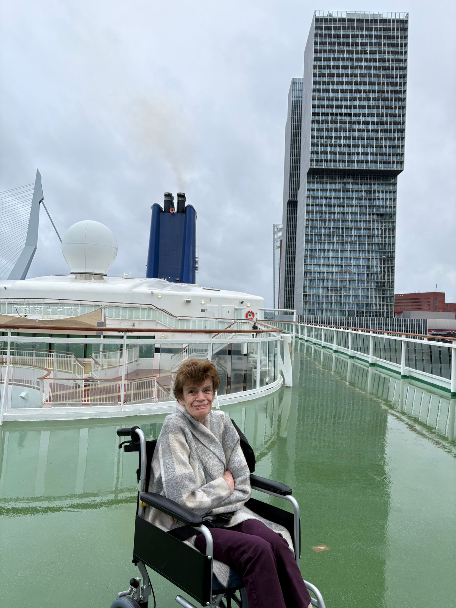 Kate sits on the top deck of a cruise ship smiling at the camera