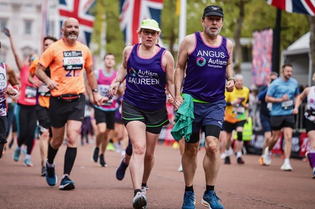 A photo of runners with flags including two people wearing Autism Hampshire t-shirts.