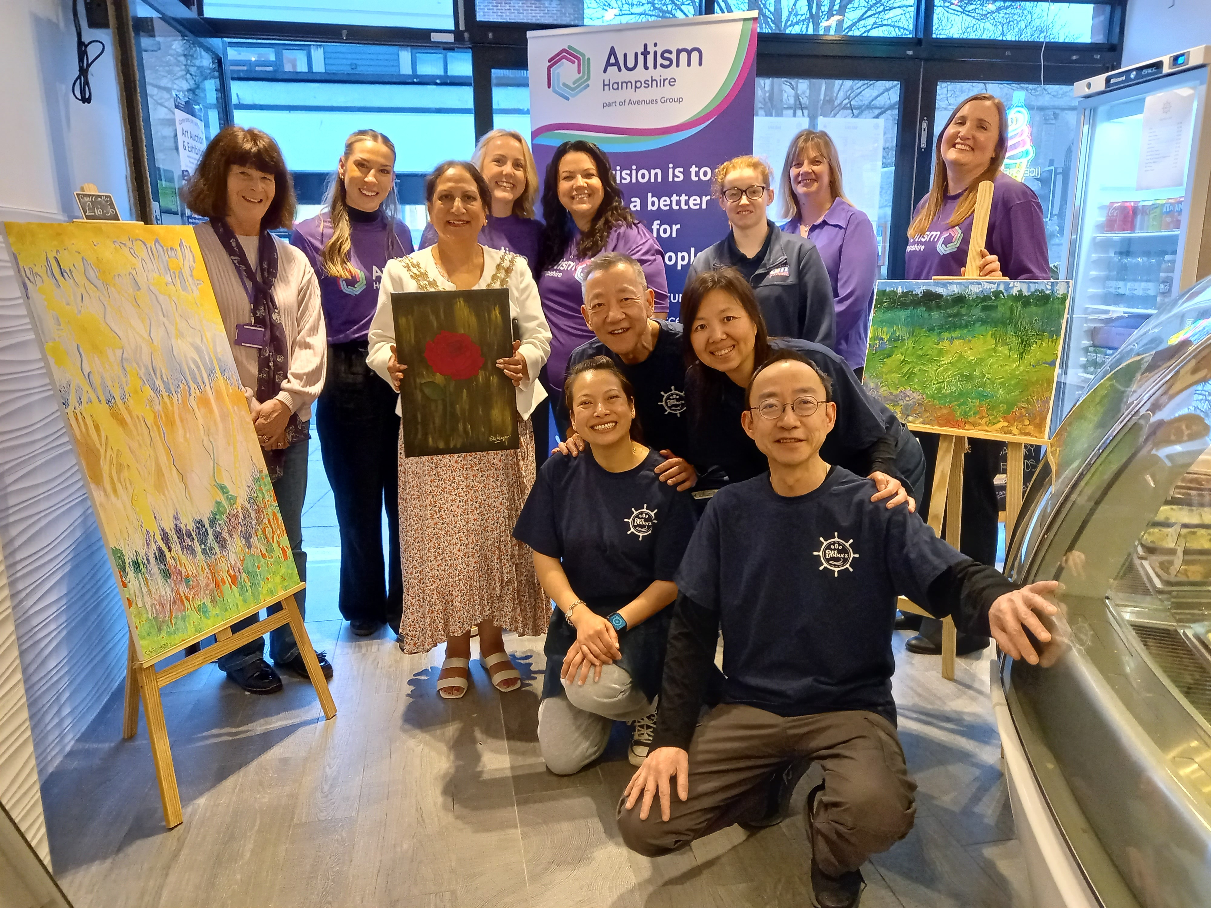 The family behind Cafe Lamma'z and Mayor of Fareham, Councillor Pal Hayre, poses with Autism Hampshire staff at the art exhibition.