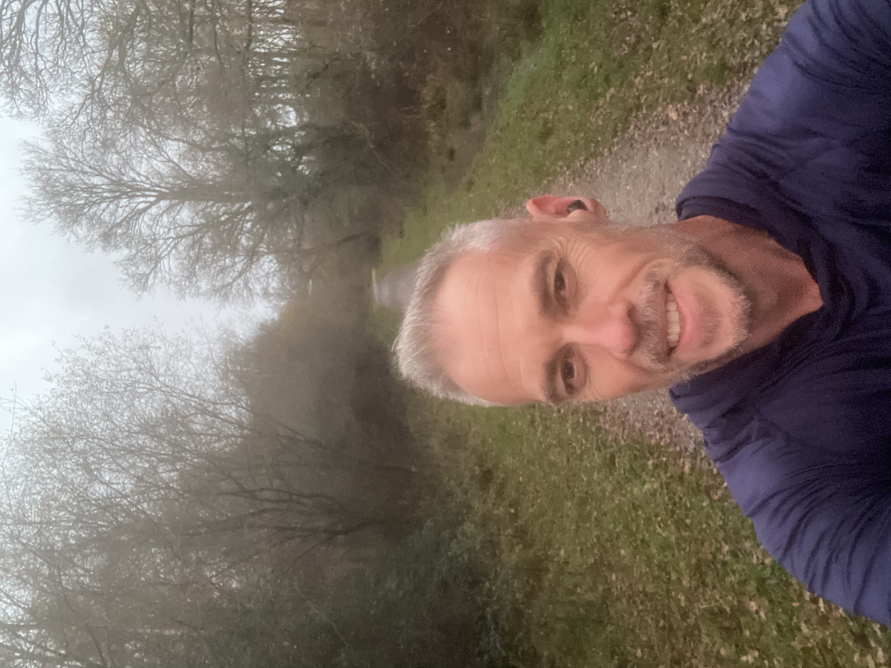 Ben Glover runs down a country path smiling at the camera.