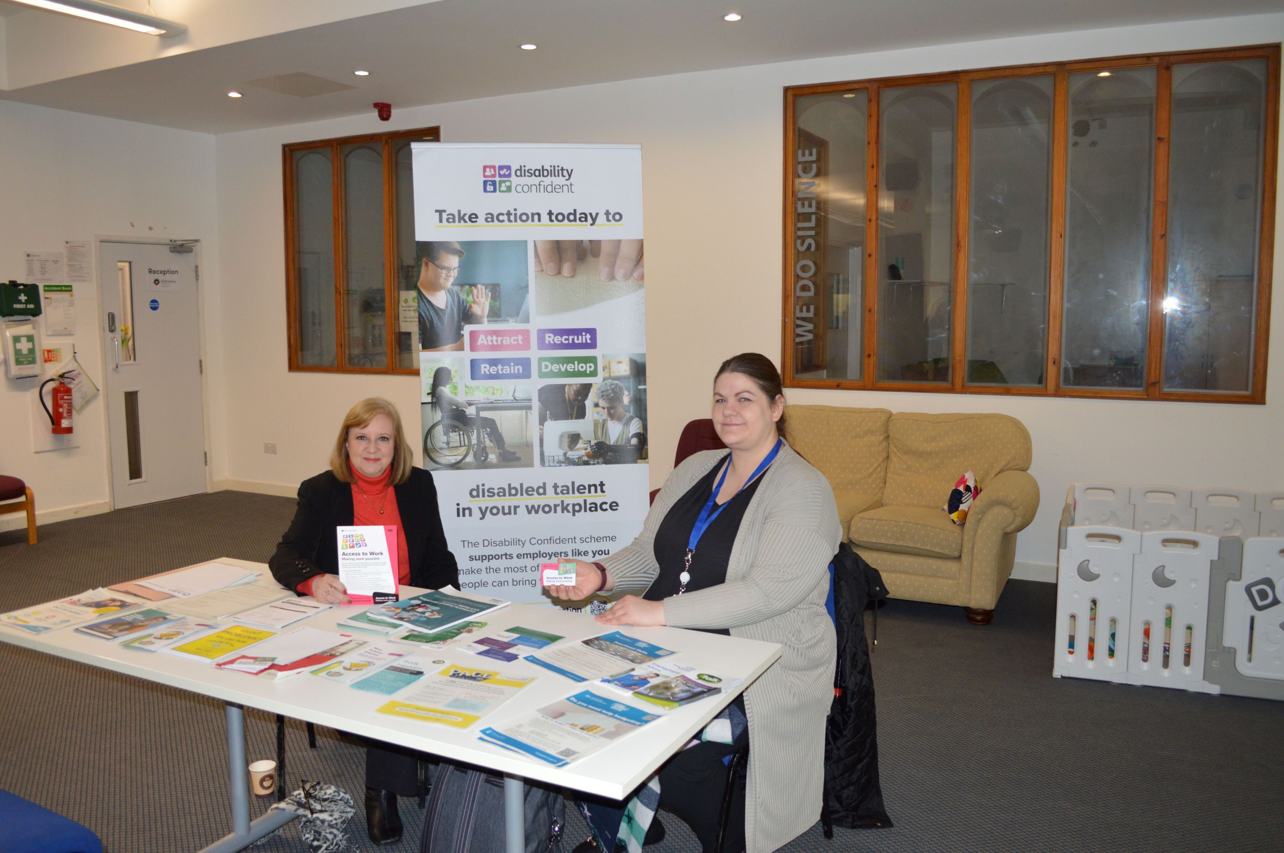 Disability Confident team at an events table with flyers and posters