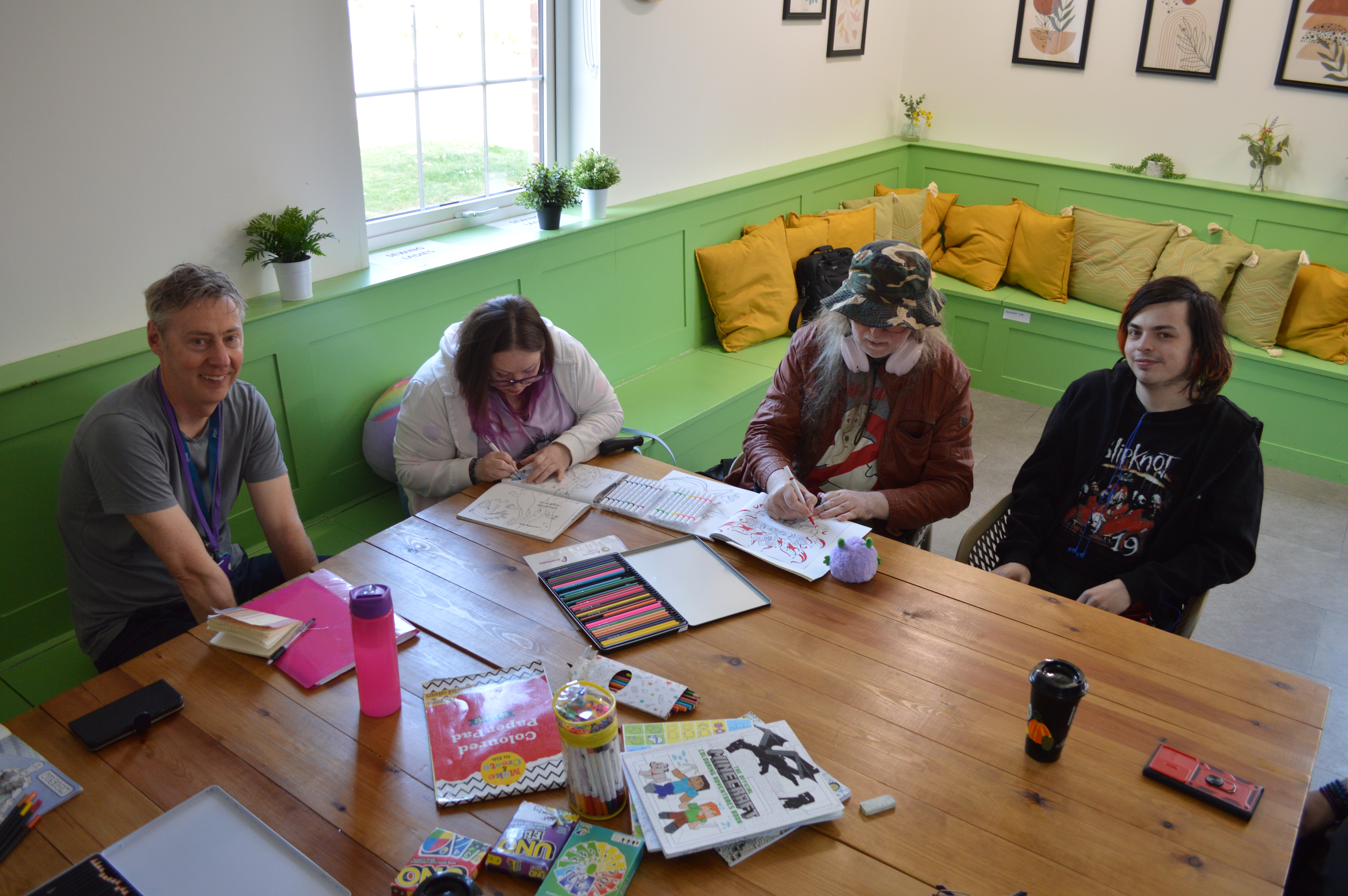 Photo of four people sitting around a table at a Serendipity group.