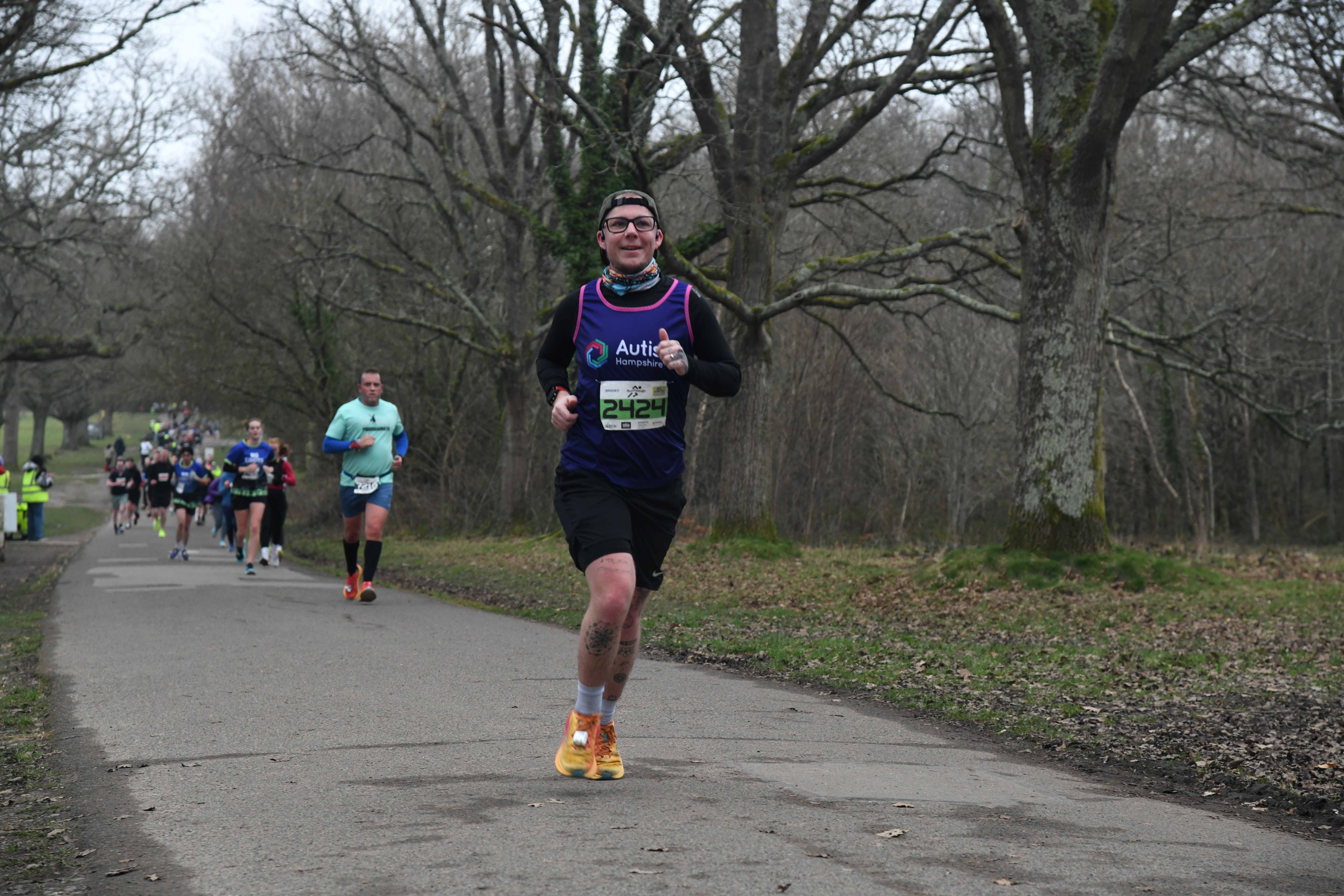Ellis running with a group of runners behind him - wearing an Autism Hampshire vest.