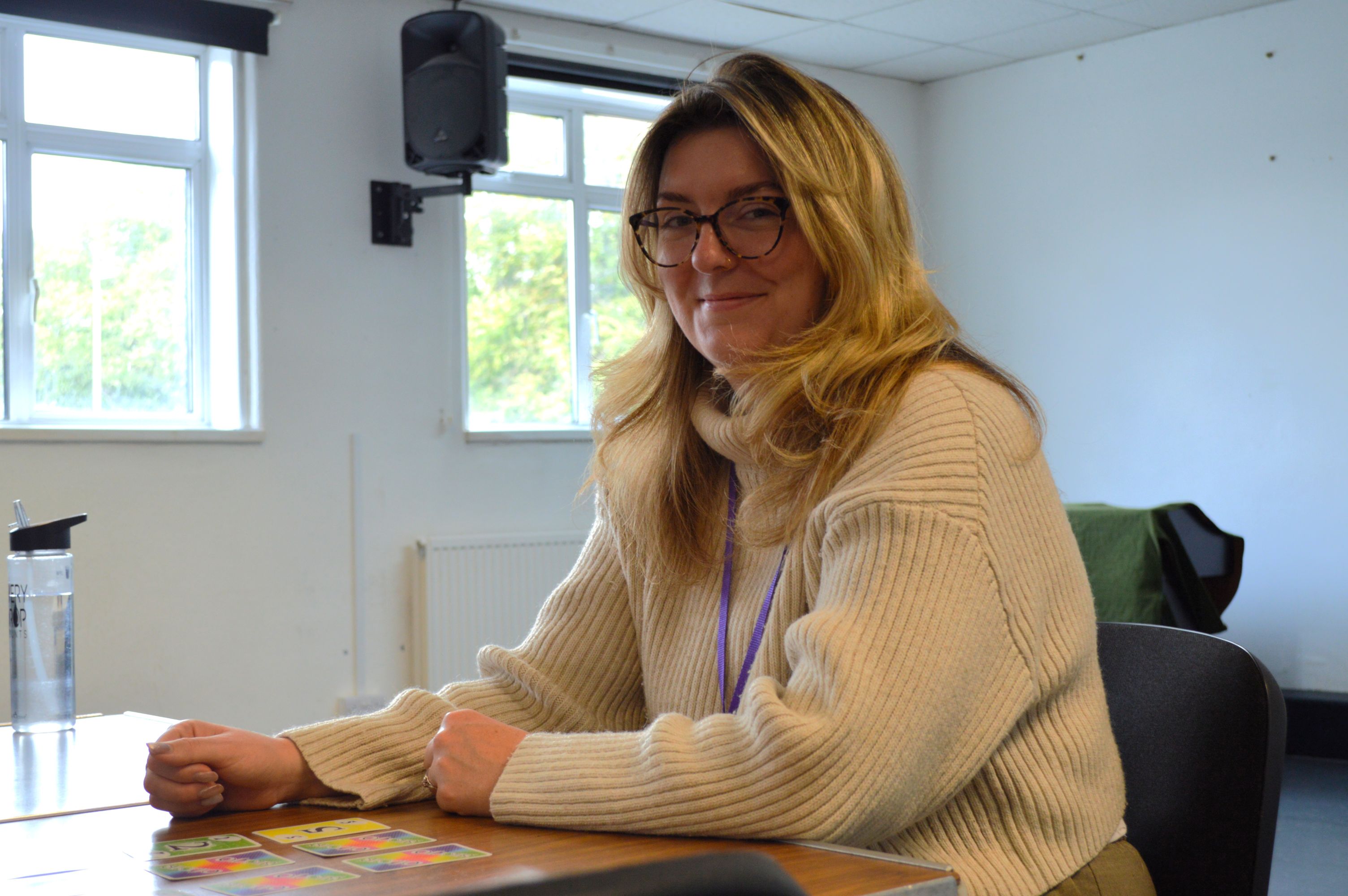 Georgie Russell sits at a table smiling at the camera