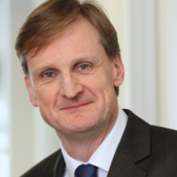 A portrait photo of Jonathan Hardie looking at the camera wearing a dark coloured suit.
