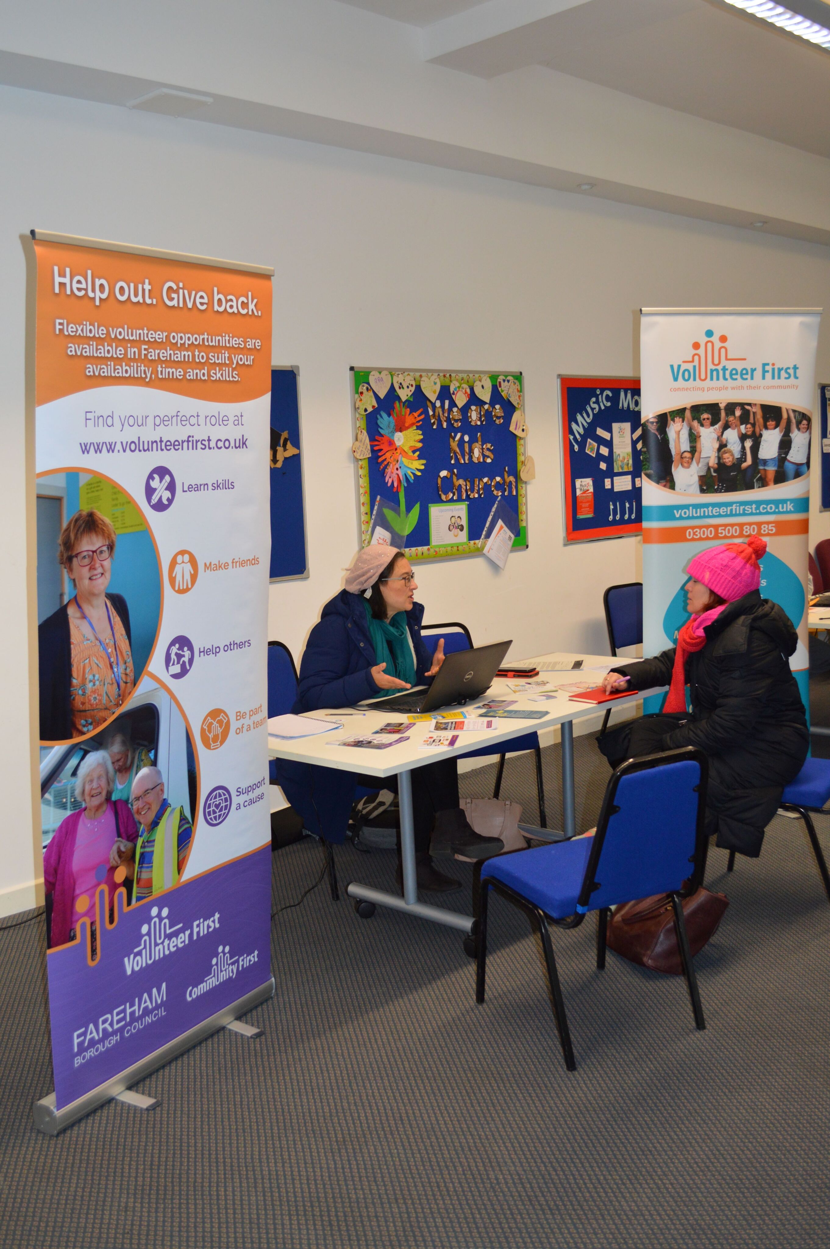 A colleague from Volunteer First talking to someone over a table and giving them advice