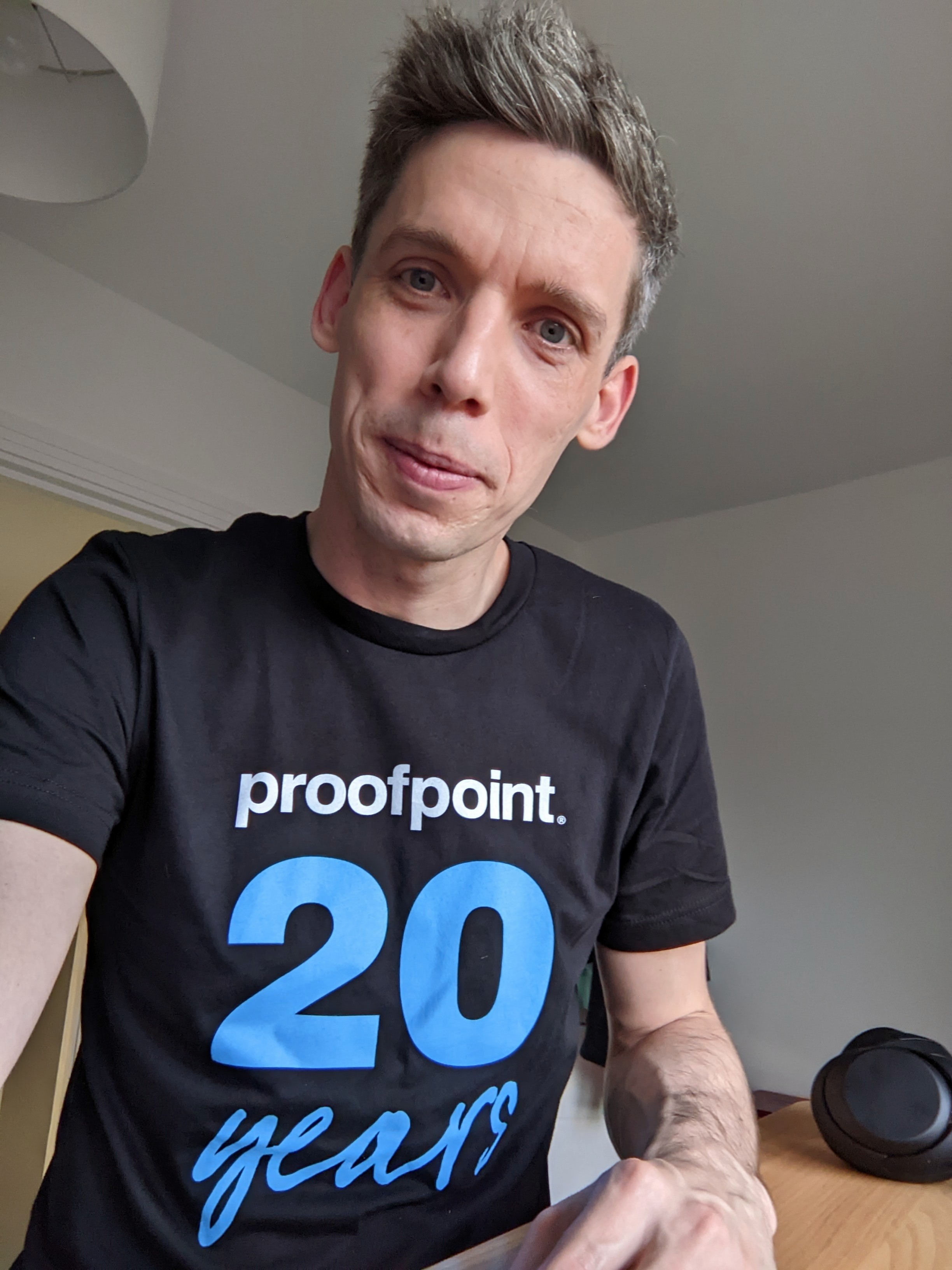 Volunteer James Sargeant smiles at the camera wearing a Proofpoint t-shirt
